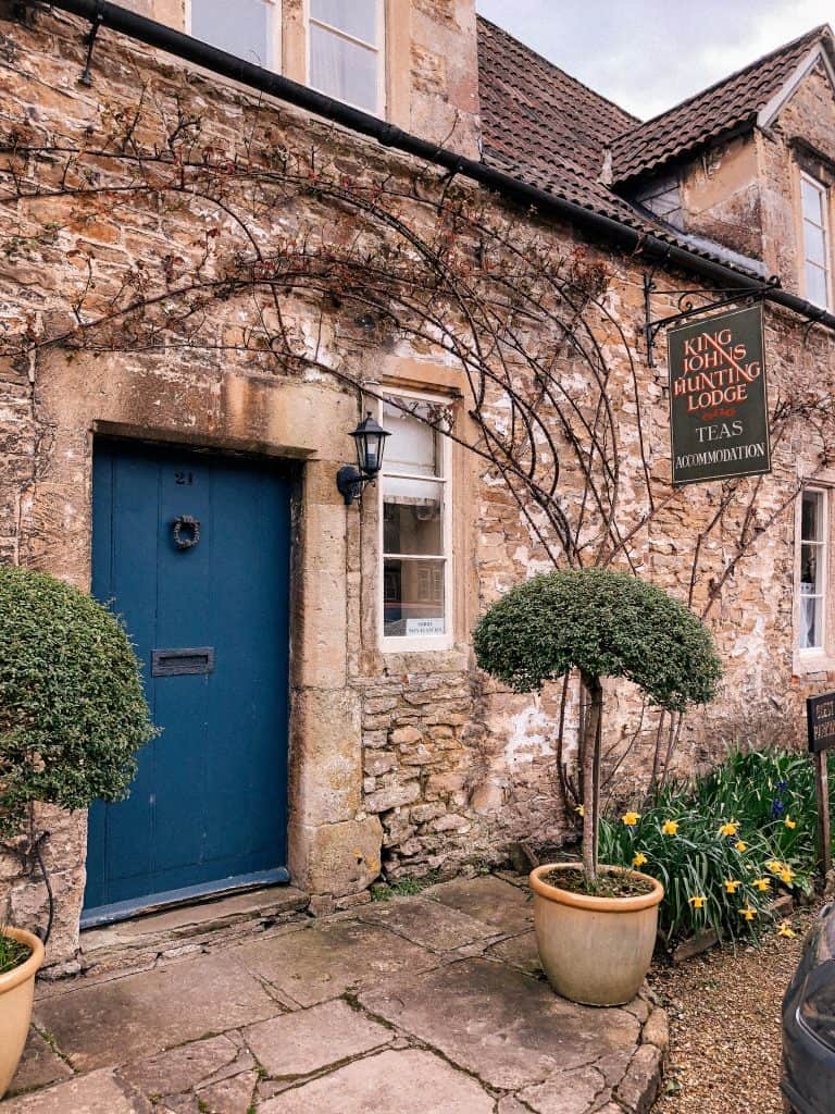 Lacock, Wiltshire, Cotswolds, UK, National Trust, England, English Countryside, blue doors, orange wheelbarrow, daffodils, spring, easter
