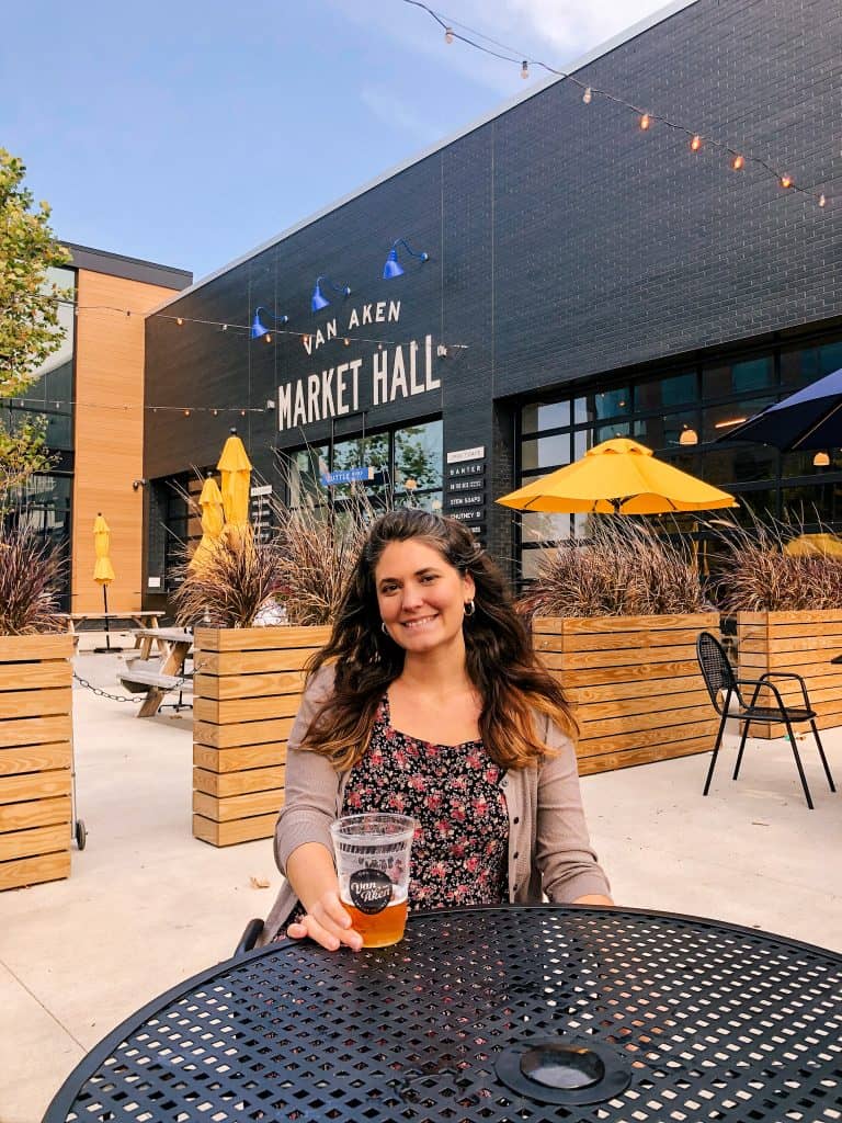 Woman drinking a local beer at the Van Aken District