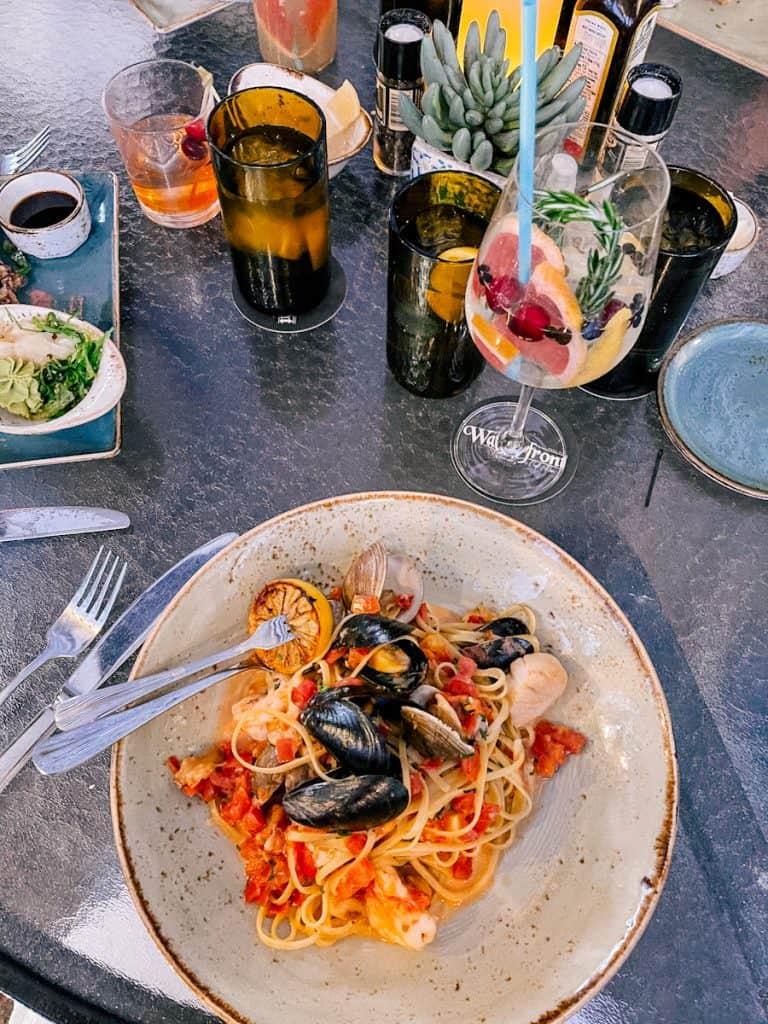 Plate of seafood pasta and gin and tonic